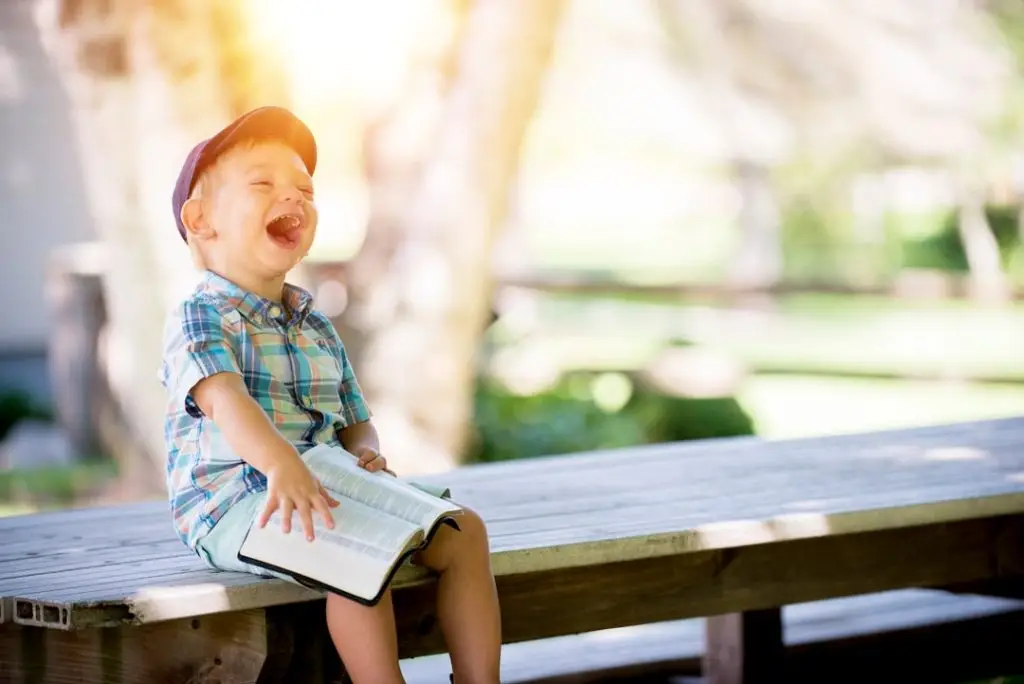 a child sitting on a bench laughing