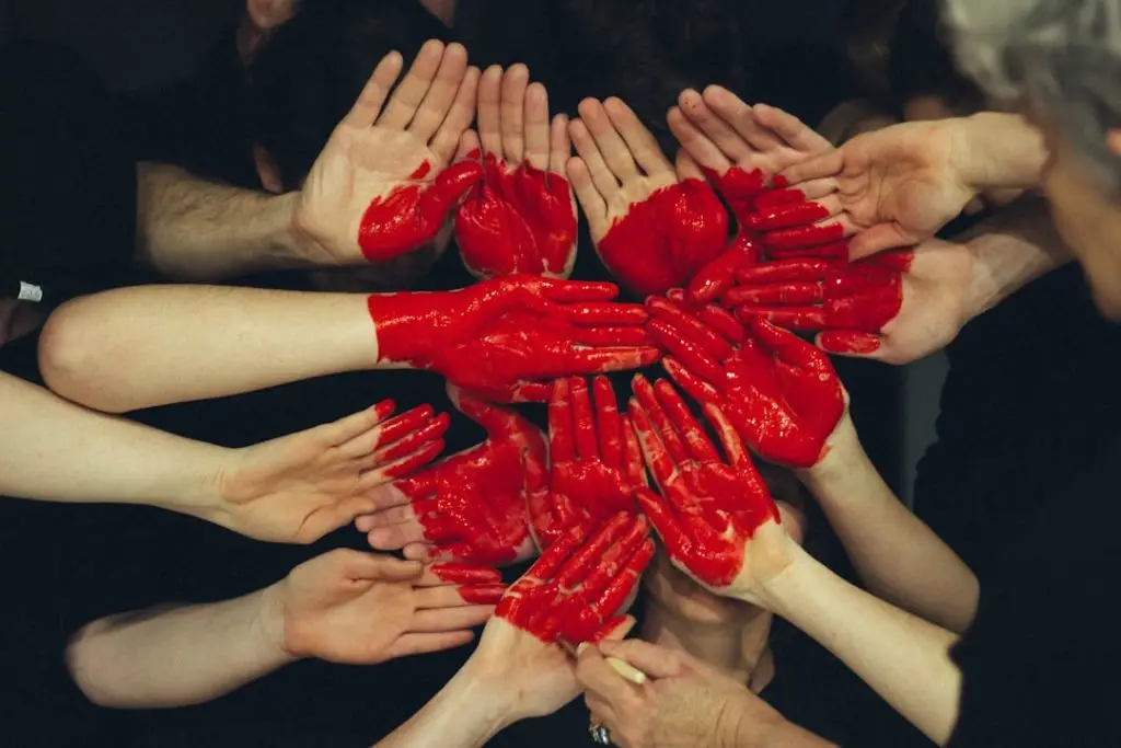 a group of hands with red paint on them