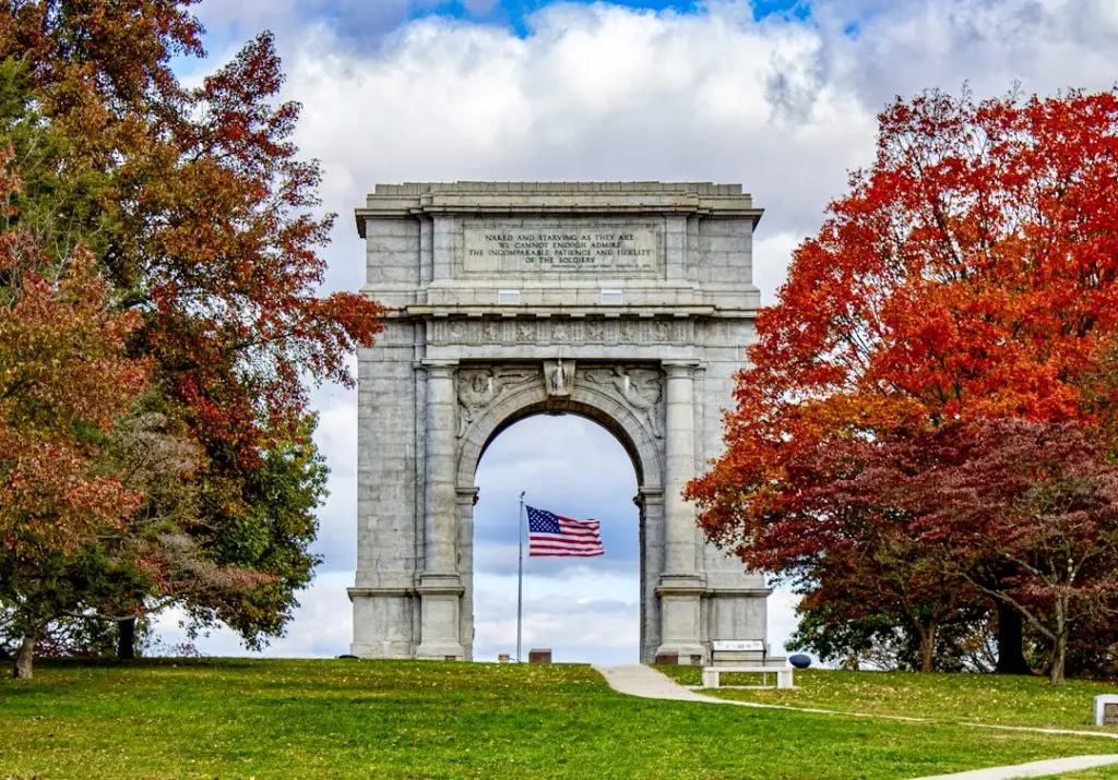 a stone arch with a flag in the background