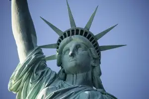 a statue of liberty with a blue sky with Statue of Liberty in the background