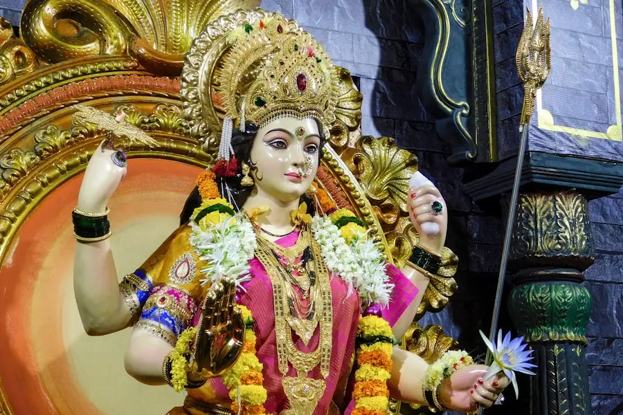 a statue of a woman with many arms and flowers