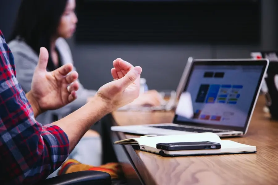 a man clapping hands in front of a laptop